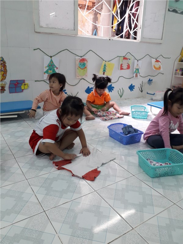 Trẻ lớp Mầm 2 thực hành xếp quần áo.
